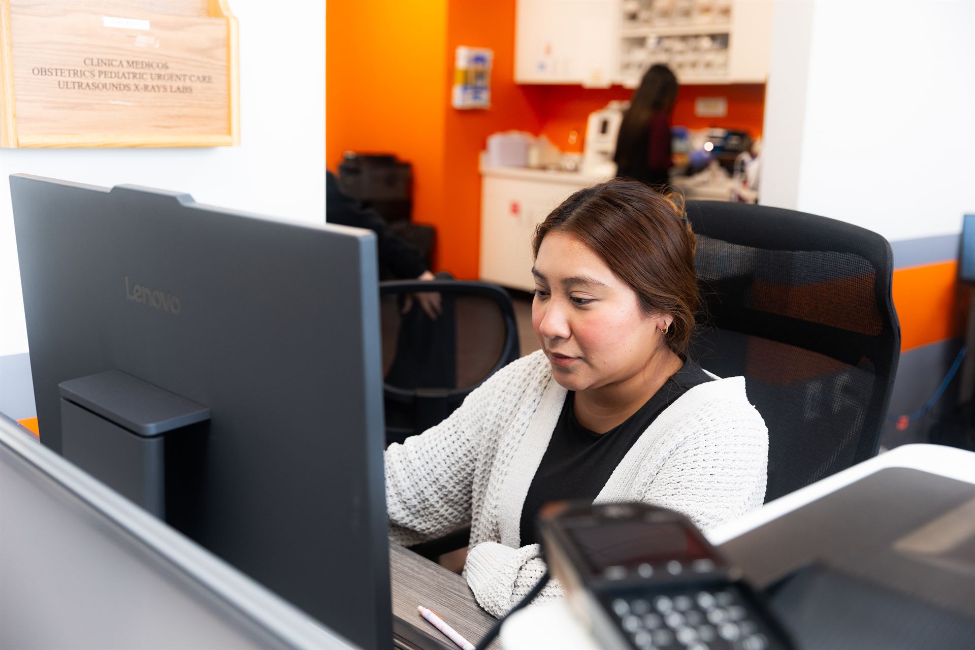 A bilingual Clínica Médicos team member at the front desk